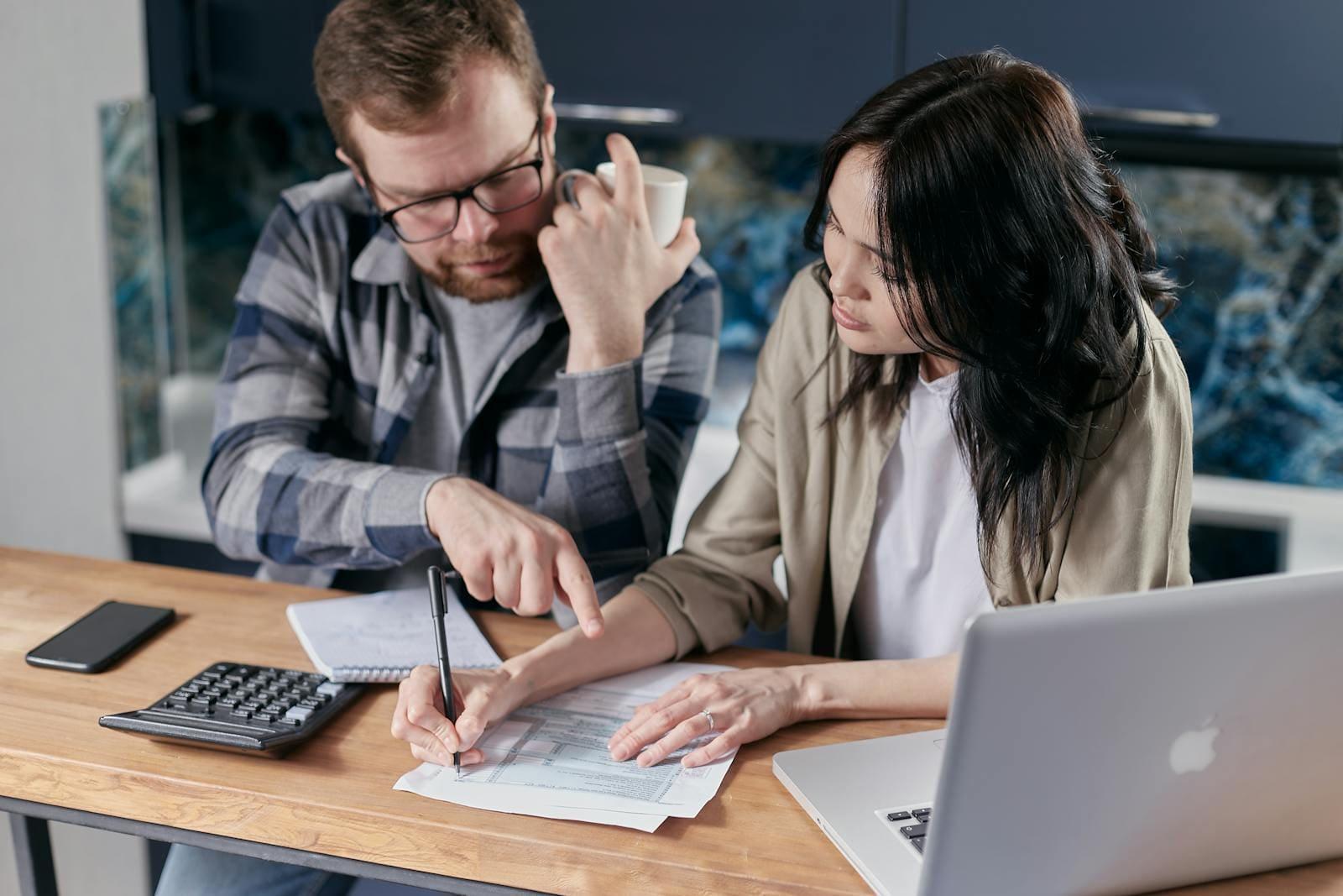A couple working through accident paperwork at their kitchen table