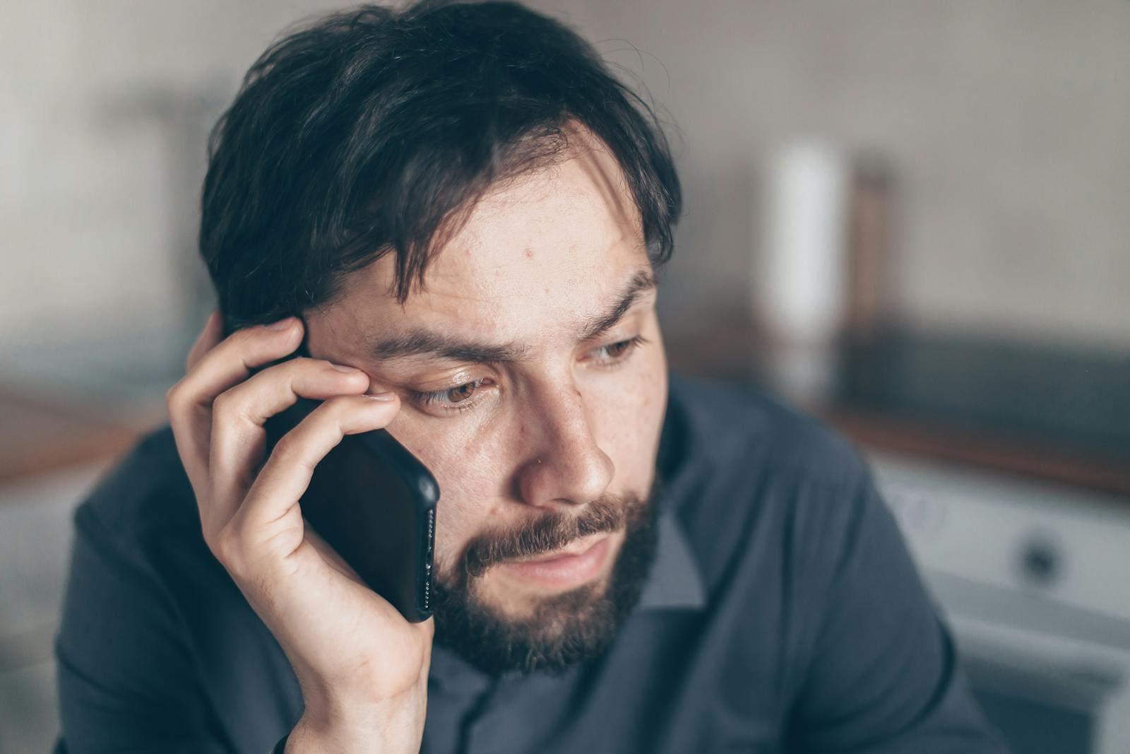 Driver on the phone after a crash, looking thoughtful