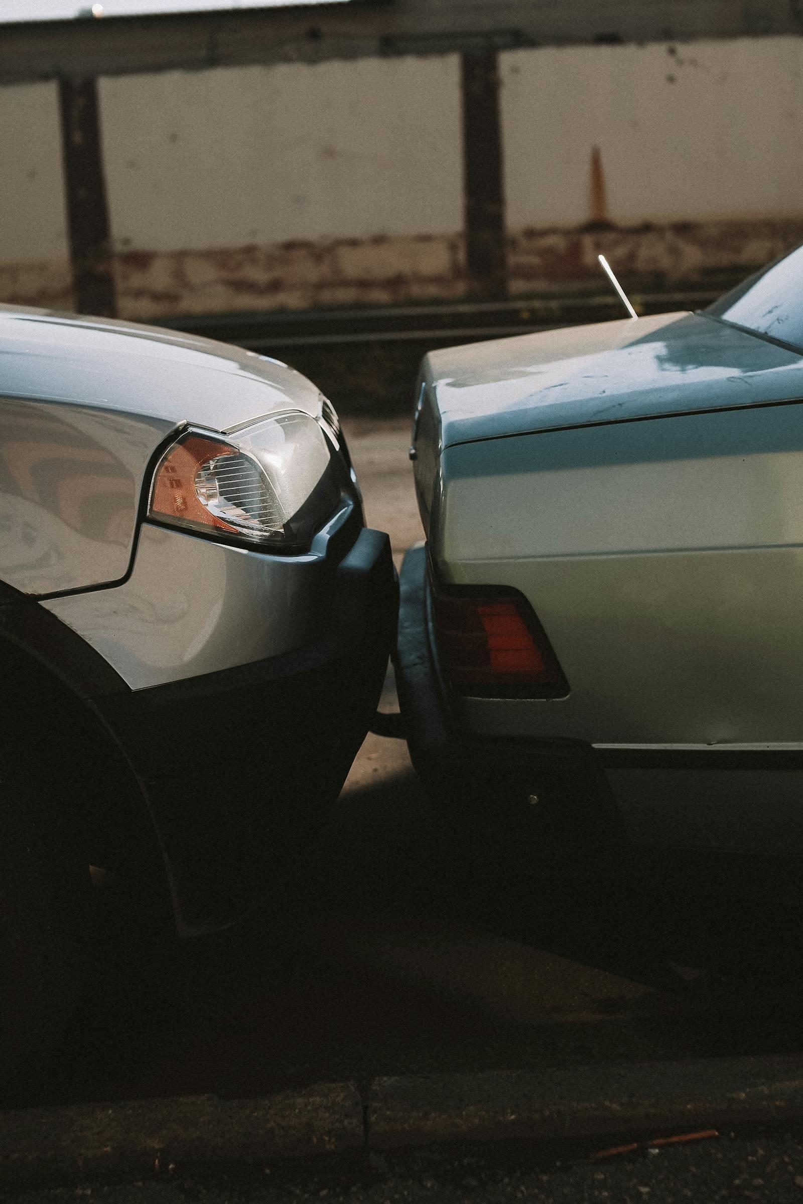 Two cars after a minor parking-lot collision, close-up of bumpers touching